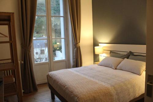 a bedroom with a bed and a large window at Appartement vue imprenable sur la Loire !!! in Saumur