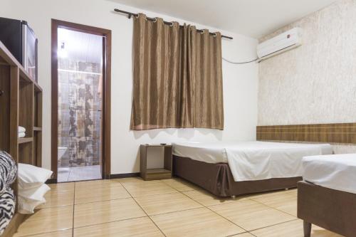 a hospital room with a bed and a window at Hotel Holiday Foz in Foz do Iguaçu
