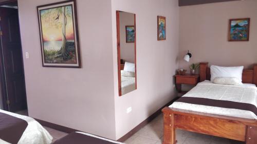 a bedroom with a bed and a mirror at Hotel Las Colinas in Fortuna