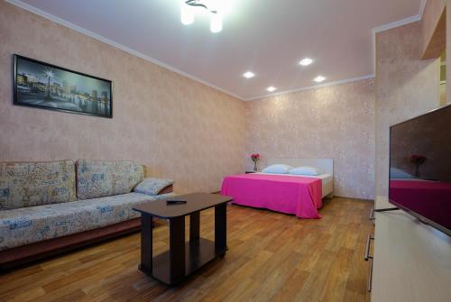 a living room with a couch and a table at ОК! Советская, 60 №1 in Tomsk