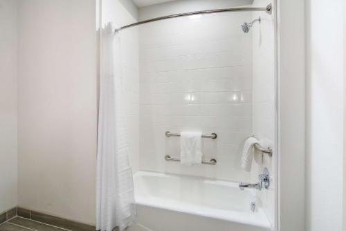 a bathroom with a white tub and a shower stall at Comfort Suites DeSoto Dallas South in DeSoto