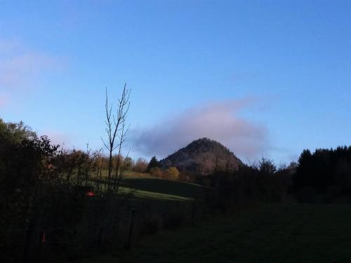 a mountain in the distance with a blue sky and clouds at Le Clos Marie in Brénod