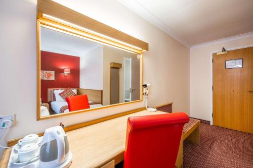 a room with a mirror and a red chair at Comfort Inn Arundel in Arundel