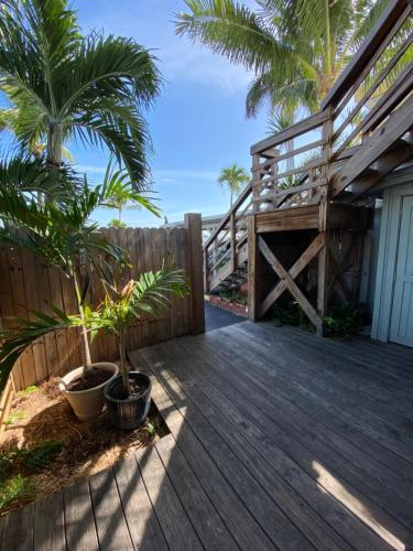 a wooden deck with palm trees and a fence at Harborside Motel & Marina in Key West