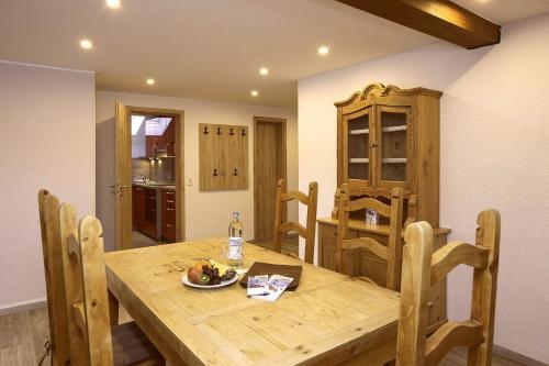 a dining room with a wooden table and chairs at Hotel Bergidyll in Pfronten