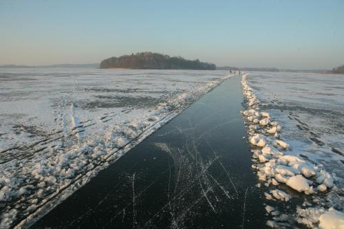 a long frozen road with snow on it at Galery69 in Dorotowo