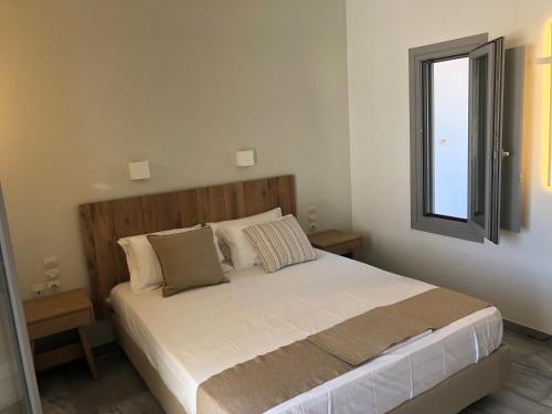 a bedroom with a large bed with a window at CAELI PAROS by Kostas & Joanna Studios in Logaras