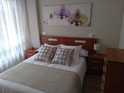 a bedroom with a bed with two fans on the wall at VUT 795 AS Apartamento Marqués de Teverga 10 in Oviedo