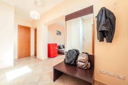 a room with a table with a backpack and a mirror at Mosaico Taormina Guest House in Taormina