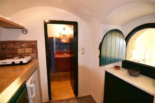 Una cocina con un fregadero y un espejo en una habitación. en Axion Studios, en Aroniadika