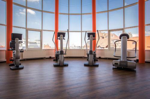 a gym with a row of exercise bikes in a room with large windows at Park Inn by Radisson Nürnberg in Nuremberg
