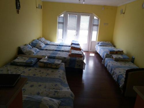 fila de camas en una habitación con ventana en Guesthouse Tomasevic en Guča