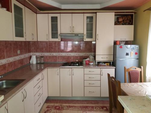 cocina con armarios blancos y nevera en Guesthouse Tomasevic, en Guča