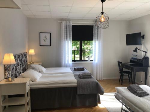 1 dormitorio con cama, escritorio y ventana en Degerfors Bed & Breakfast en Degerfors