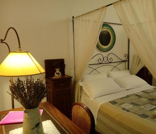 Montoro InferioreにあるLavanda E Merletti Maison De Charmeのベッドルーム1室(ベッド1台、ランプ付きテーブル付)