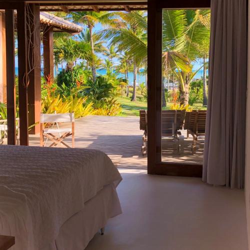 a bedroom with a bed and a view of a patio at Vila Bela Vista in Corumbau