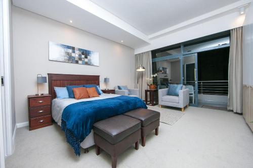 a bedroom with a large bed with a blue blanket at Ace Location walk to Sun Arena & Menlyn CBD WiFi Self Catering in Pretoria