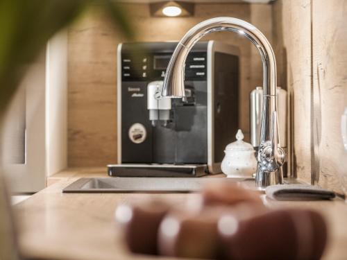 a kitchen sink with a faucet and a coffee maker at Neschtl in Ramsau im Zillertal