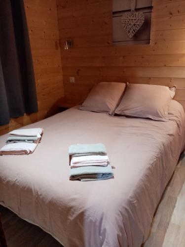 une chambre avec un lit blanc avec des serviettes dessus dans l'établissement Le chalet douillet, à Saint-Geniès