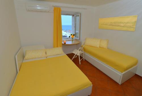 Una pequeña habitación con dos camas y una ventana. en Apart Seaview Piran, en Piran