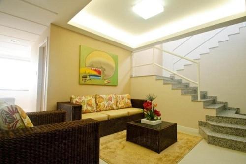 een woonkamer met een bank en een trap bij HOTEL LUCIANA in Serrinha