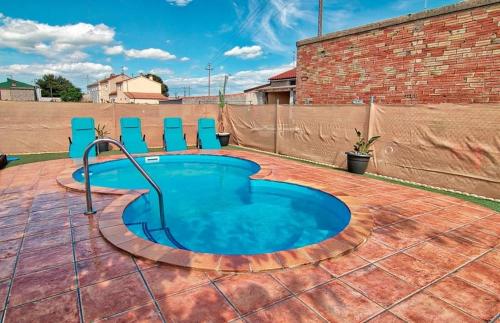 a small swimming pool on a brick patio with blue chairs at Casetes Joan de Pataca 3 in Deltebre