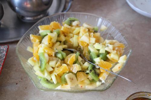 Una ensalada en un recipiente de vidrio con una cuchara dentro. en Chambre de l'Orée du Bois, en Audeux