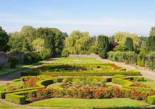a garden with many flowers and hedges at The Lodges at Kilkea Castle in Kilkea