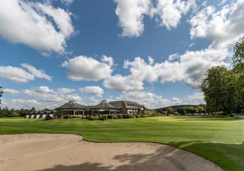 a view of a golf course with a house at The Lodges at Kilkea Castle in Kilkea