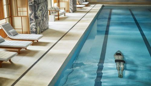 a man in a swimming pool with a penguin in the water at Four Seasons Hotel New York Downtown in New York