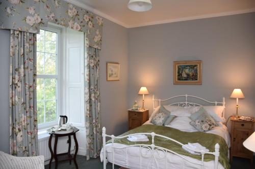 a bedroom with a bed and a window at Applegarth House in Lockerbie