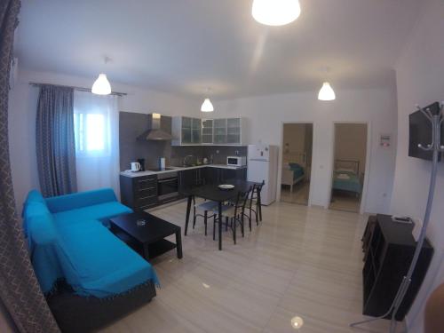 a living room with a blue couch and a kitchen at Kanellos luxury apartments in Paleros