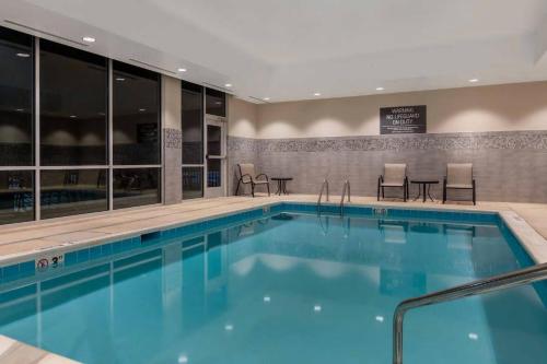 a pool in a hotel with chairs and tables at La Quinta Inn & Suites by Wyndham Wisconsin Dells- Lake Delton in Wisconsin Dells
