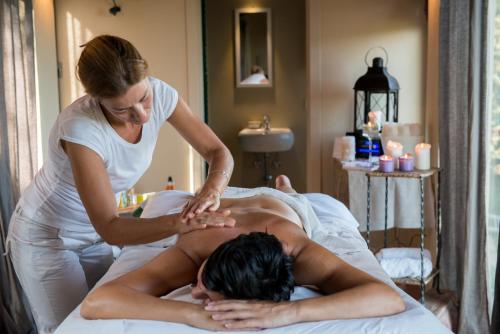 a woman giving a man a massage on a bed at Salvadonica in San Casciano in Val di Pesa