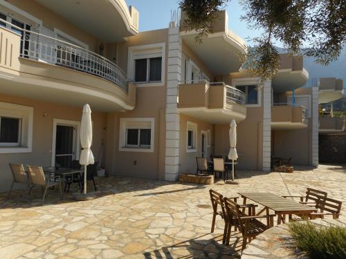 un patio avec une table et des chaises et un bâtiment dans l'établissement Kanellos luxury apartments, à Paleros