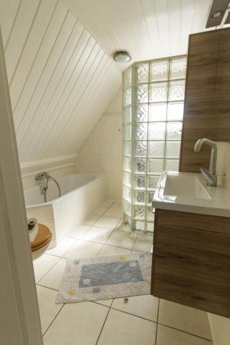 a bathroom with a bath tub and a sink at Home sweet home in Breskens
