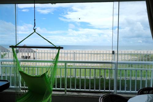 a hammock in a room with a view of the beach at TERRAMARIS - APARTAMENTO PÉ NA AREIA in Aquiraz