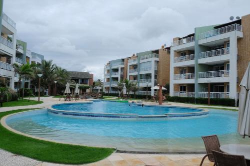 een groot zwembad voor sommige appartementsgebouwen bij TERRAMARIS - APARTAMENTO PÉ NA AREIA in Aquiraz