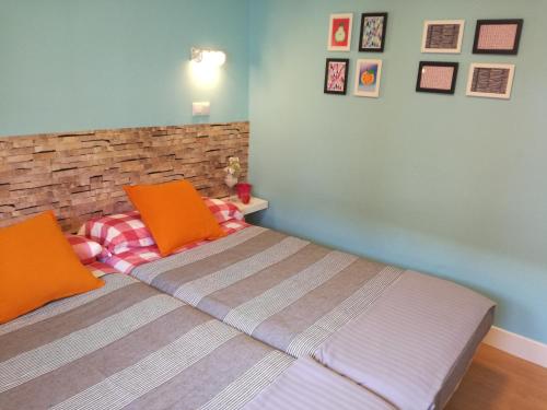 ein Schlafzimmer mit einem Bett mit orangefarbenen Kissen darauf in der Unterkunft Apartamento Talako in Bermeo