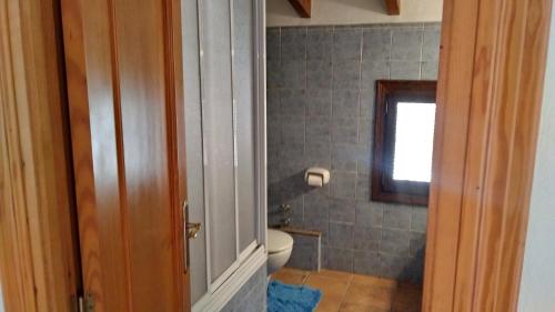 uma casa de banho com um WC e uma janela em Larnella em Teulada