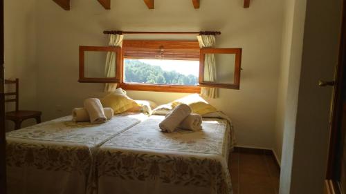 1 dormitorio con 1 cama y ventana en Larnella, en Teulada
