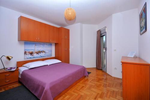 una camera con letto viola e armadi in legno di ANTOS Put Gaja, Split a Spalato (Split)