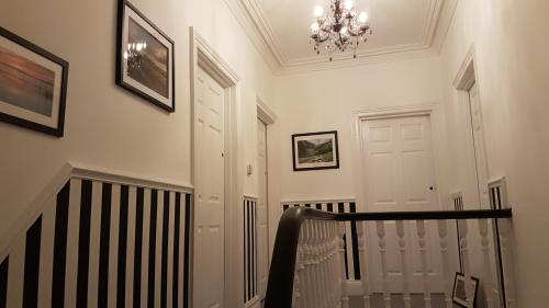 a hallway with a staircase with a chandelier at Oakover Guest House in Weston-super-Mare