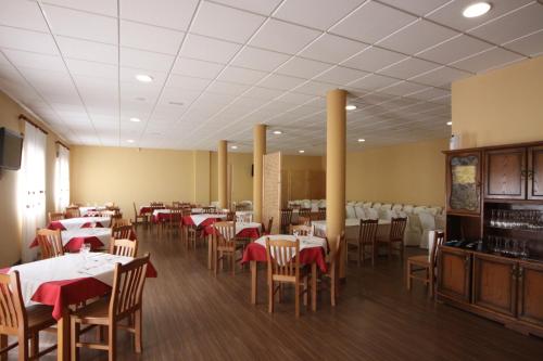 a dining room with tables and chairs with red napkins at Hostal Restaurante El Silo in Santa María del Páramo
