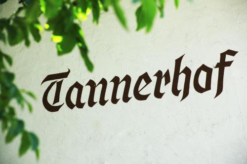 a word painted on a white wall with leaves at Tannerhof Bed & Breakfast in Caines