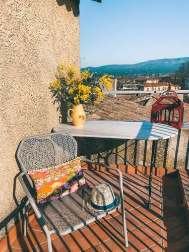 d'une table, d'une chaise et d'un chapeau sur le balcon. dans l'établissement LE BELVEDERE, à LʼIsle-sur-la-Sorgue
