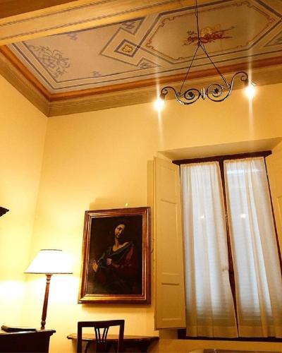 a room with a painting of a woman on the wall at Hotel Santa Caterina in Siena