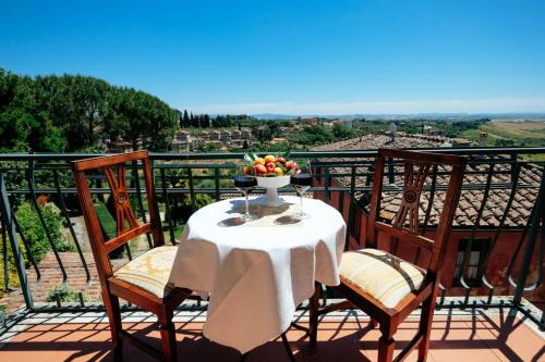a table with a bowl of fruit on a balcony at Hotel Santa Caterina in Siena