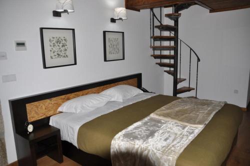a bedroom with a bed and a spiral staircase at Quinta do Olival in Vilas Boas