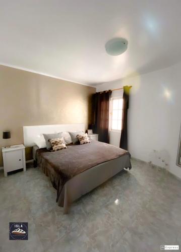 a bedroom with a large bed and a window at Old Town Puerto del Carmen in Puerto del Carmen